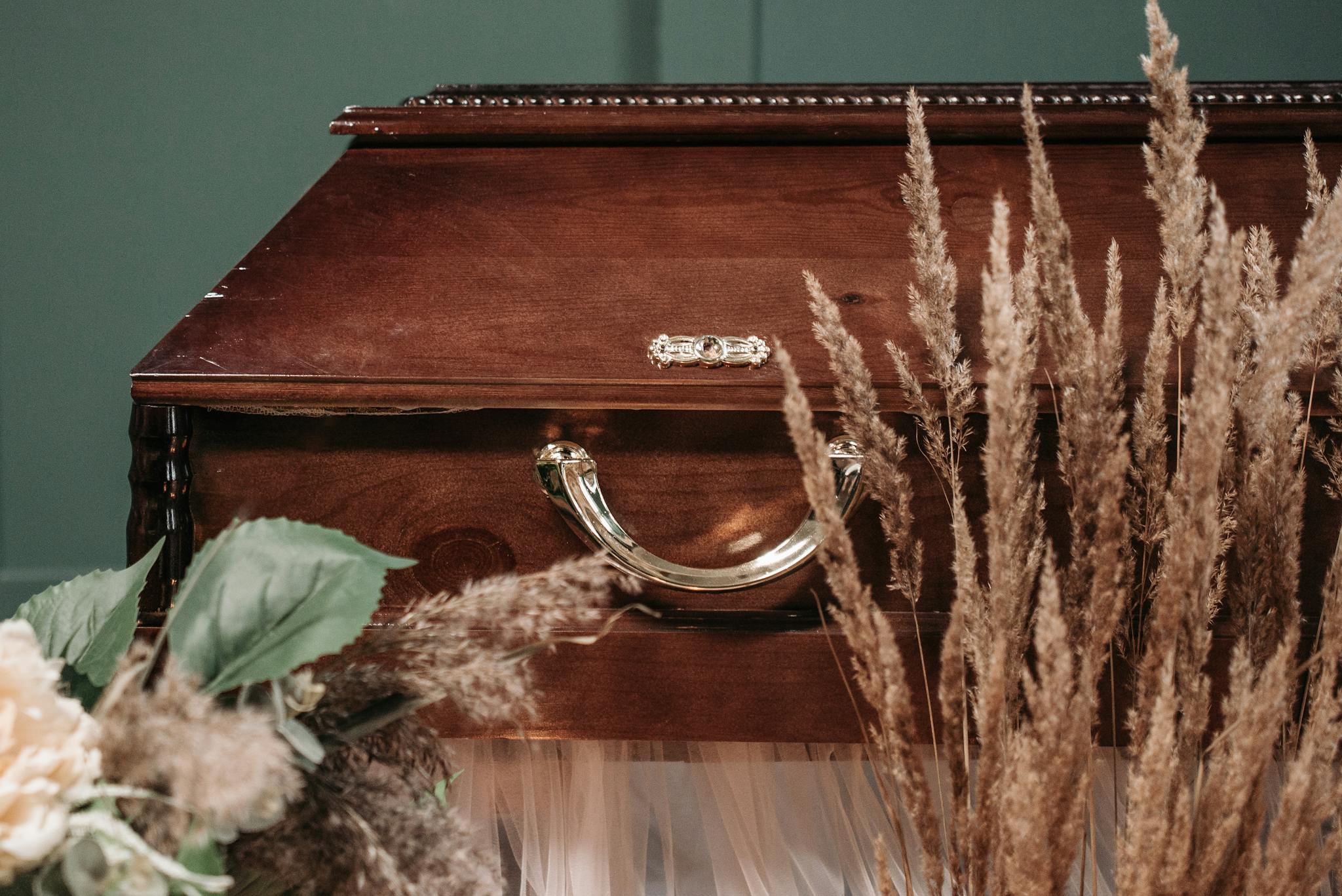 A beautifully crafted wooden coffin adorned with dried flowers, evoking a serene and respectful atmosphere.